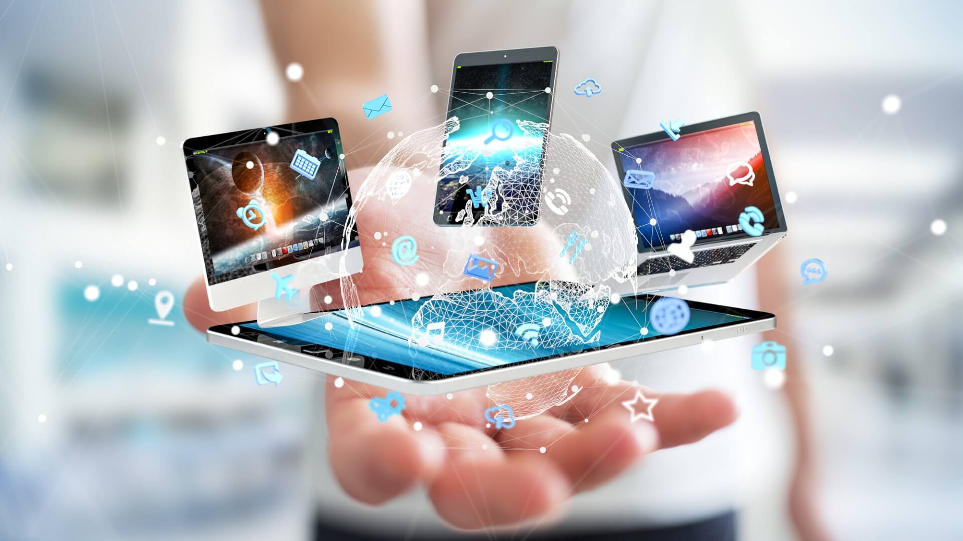 A hand holding high tech tablet, smartphone and other techology gadgets