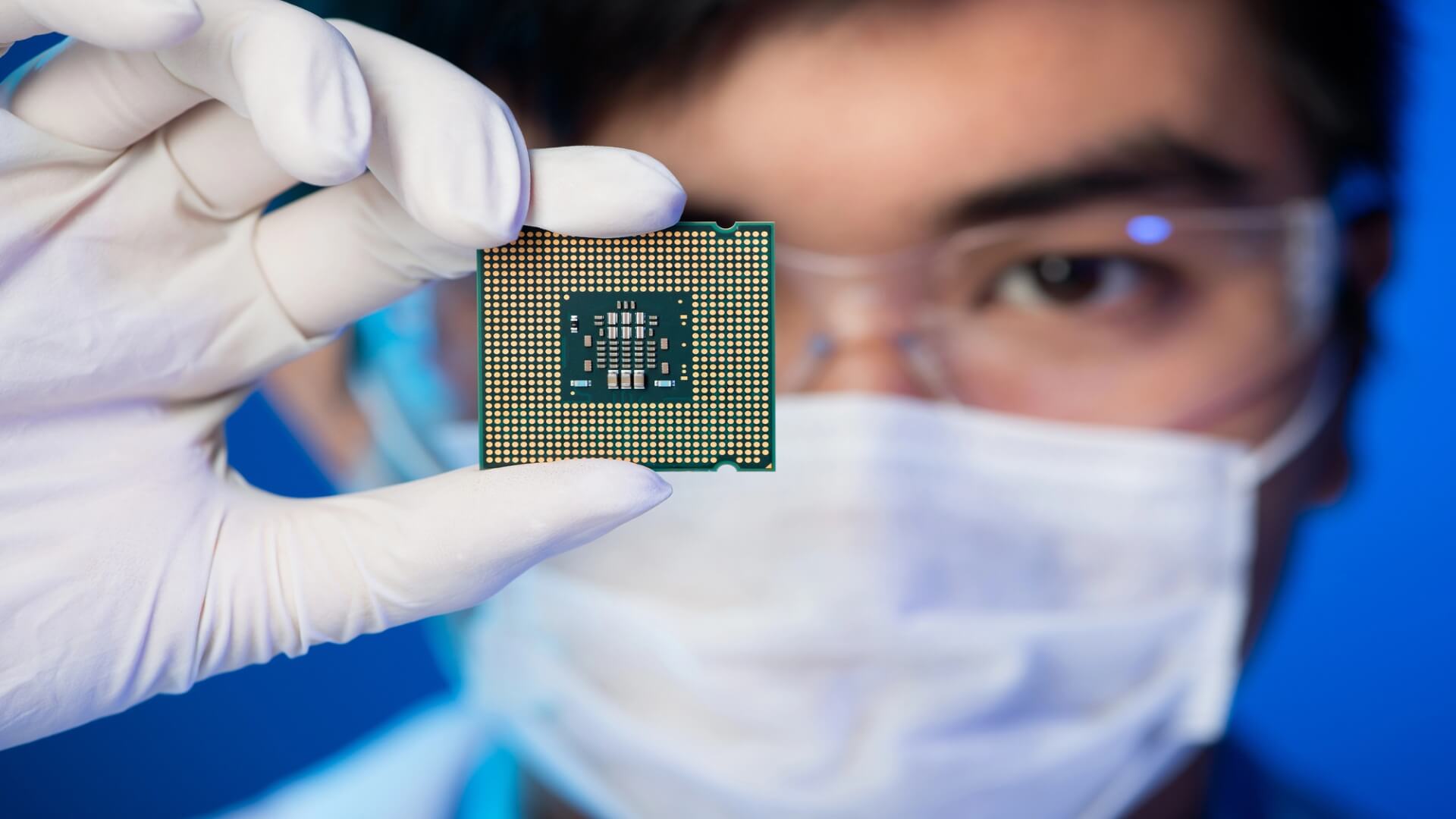 Masked and gloved engineer holding a chip